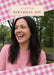 Angled pink gingham panels border a large photo, with a cream rectangular label carrying small burgundy serif birthday wording.