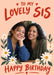 Lovely Sis birthday photo card with cream flowers, green leaves, a peach background and red lettering, shown with two smiling women sitting together indoors.